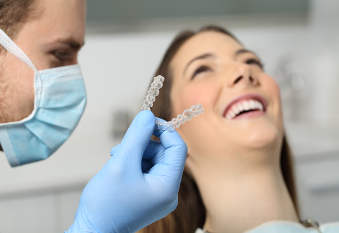 Dental doctor checking his female patient in his clinic